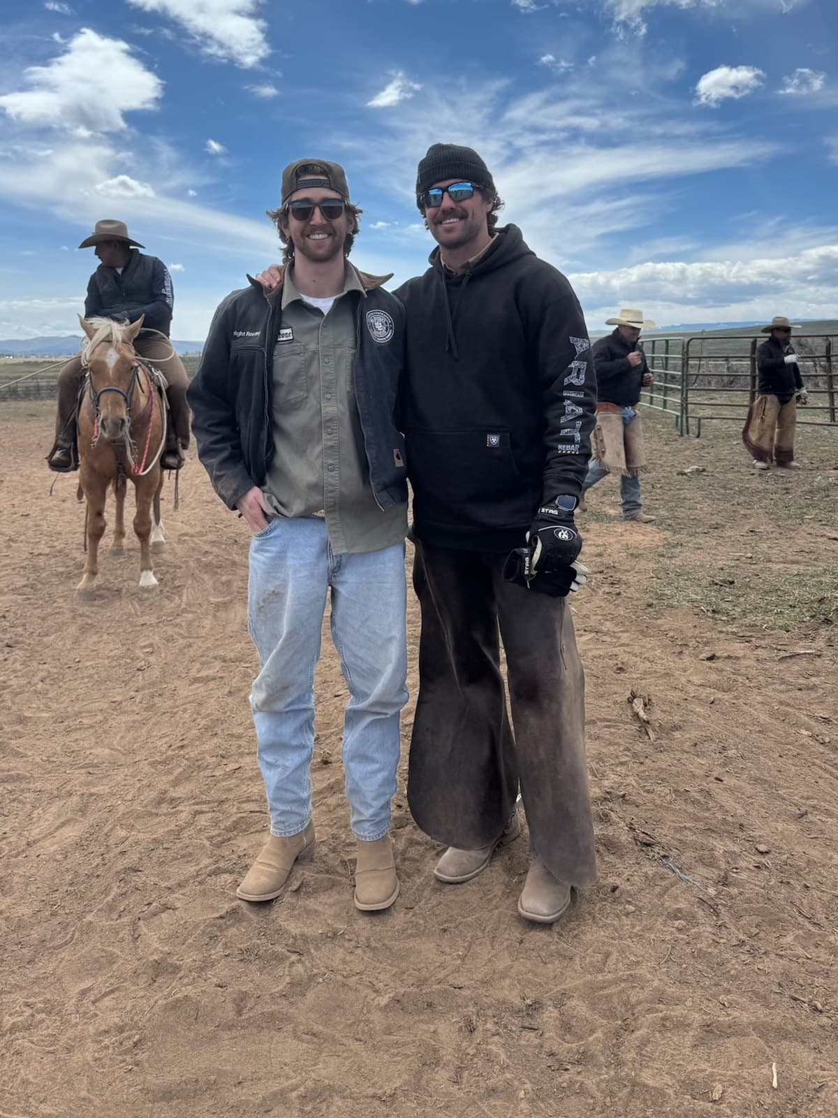 Brimstone's two founders standing together at the corrals, a saddled horse behind them