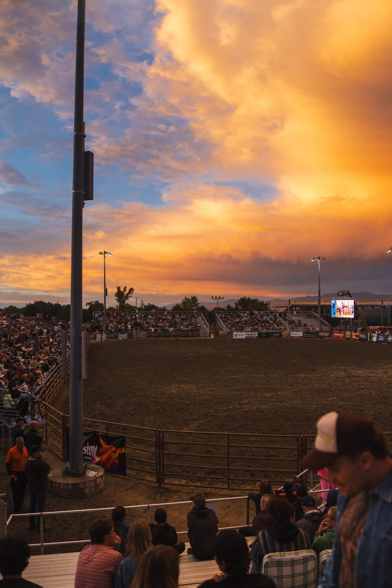 The grandstand full of people under an orange storm sky