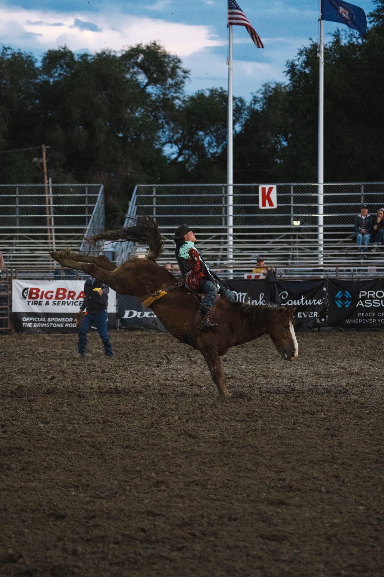 A bronc out of the chute with the flags up behind